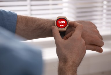 Image of Man using SOS function on smartwatch indoors, closeup