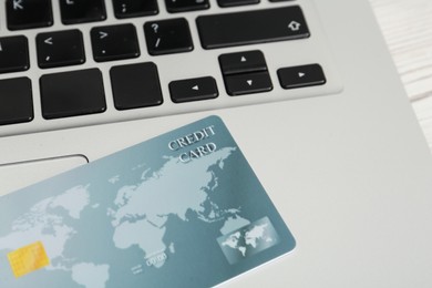 Online payment concept. Bank card on laptop keyboard, closeup