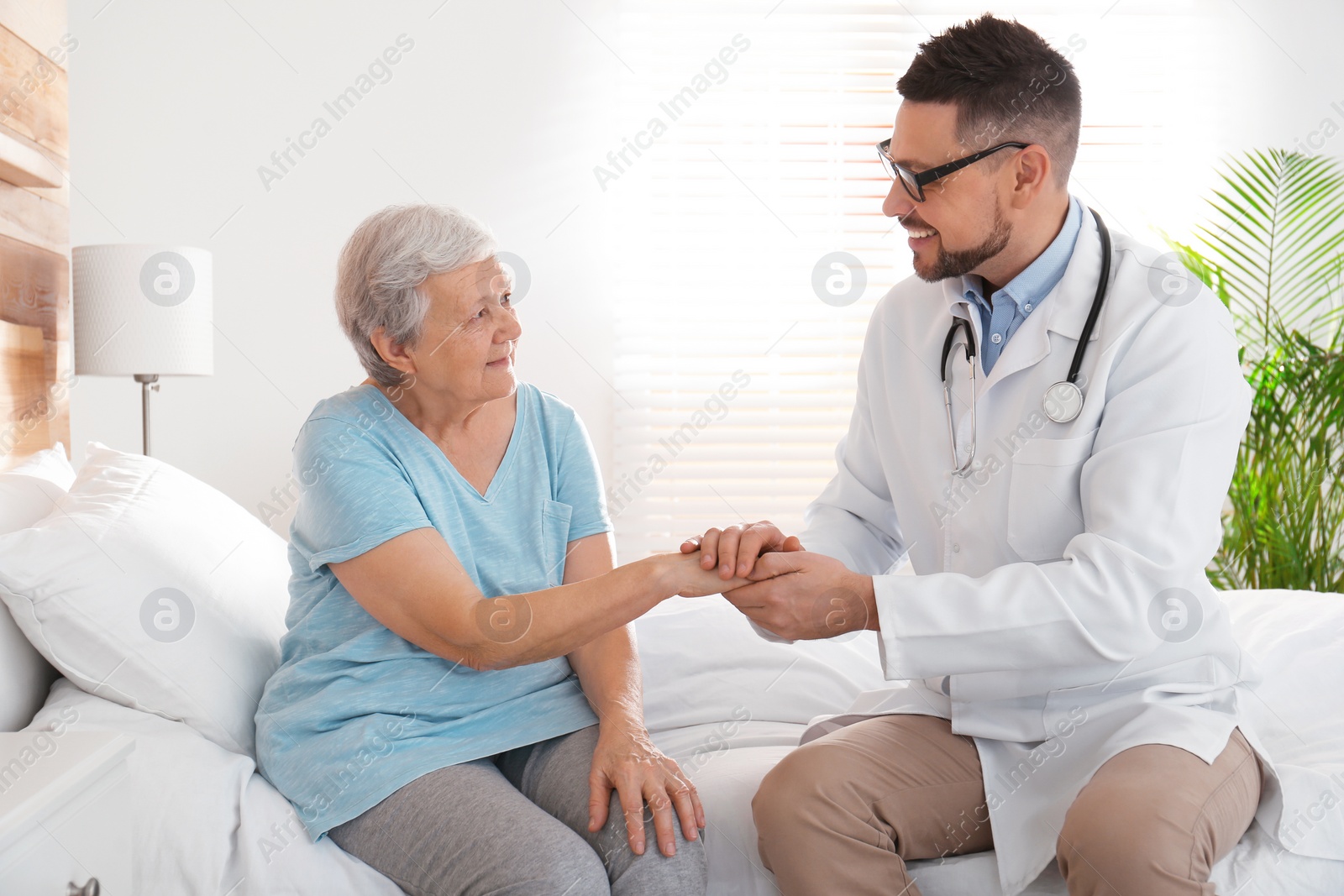 Photo of Doctor visiting senior patient in modern hospital