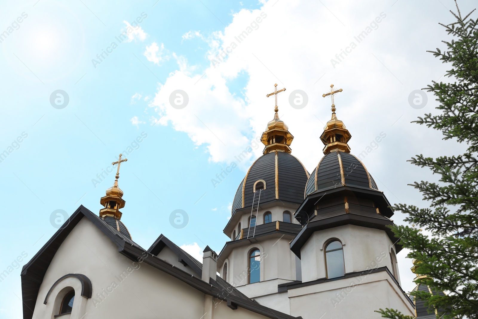Photo of Beautiful church with golden domes against cloudy sky