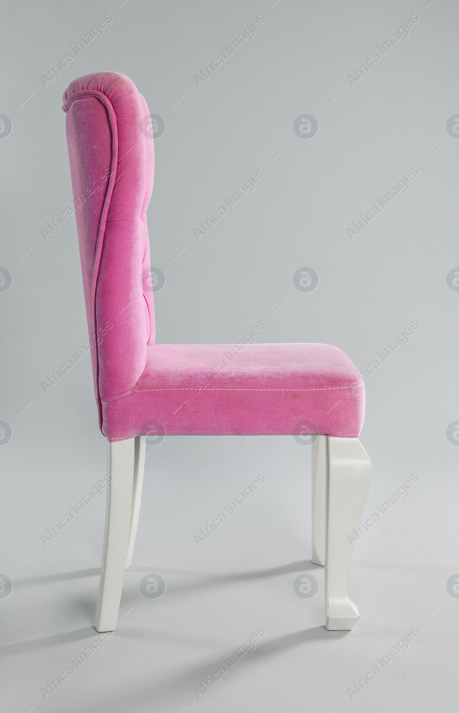 Photo of Stylish pink chair on light grey background. Element of interior design