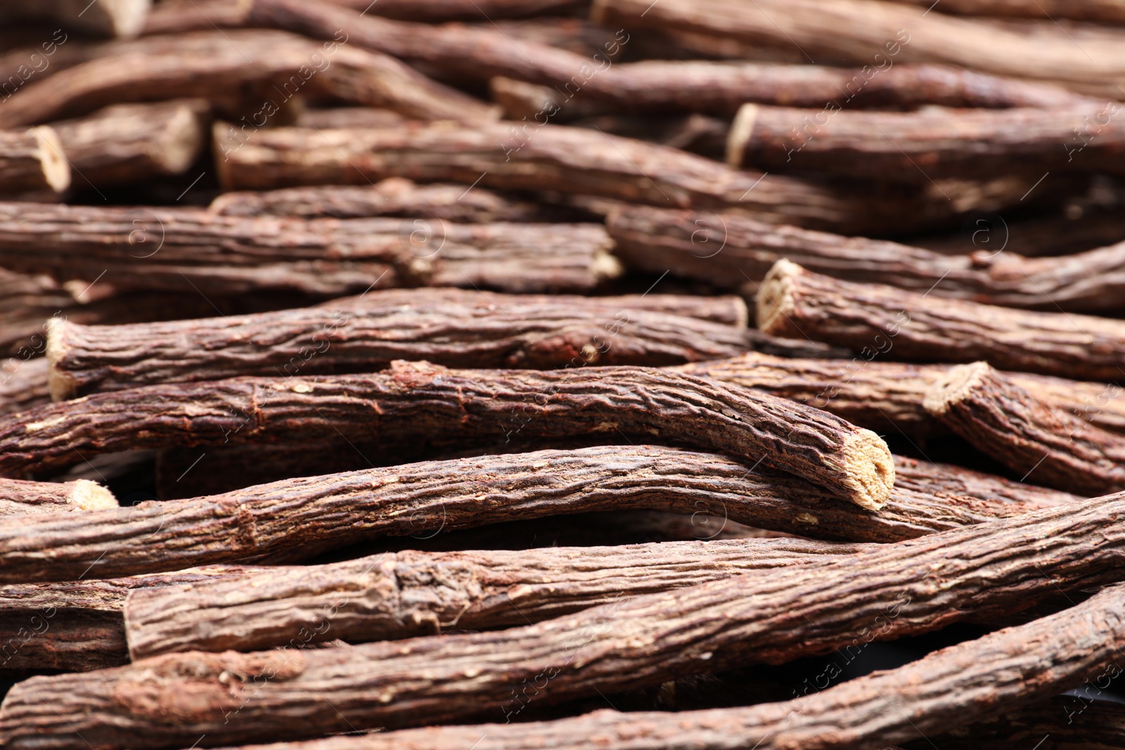 Photo of Dried sticks of liquorice root as background, closeup
