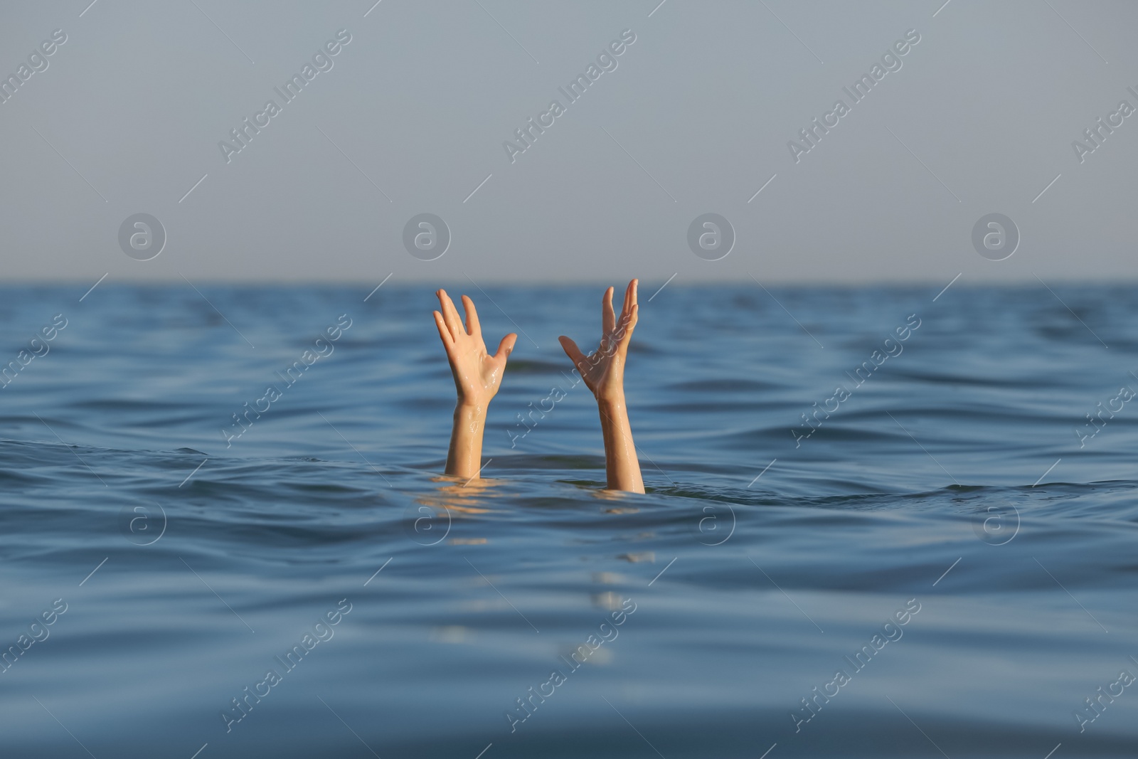 Photo of Drowning woman reaching for help in sea