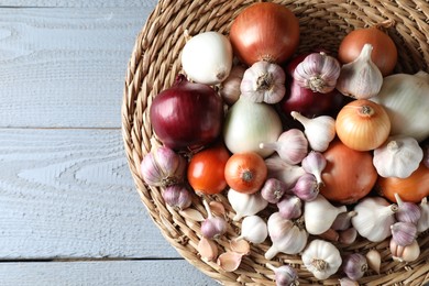 Fresh raw garlic and onions on gray wooden table, top view. Space for text