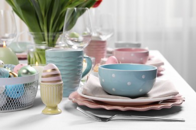 Photo of Festive table setting with painted eggs. Easter celebration