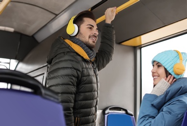 Young people listening to music with headphones in public transport