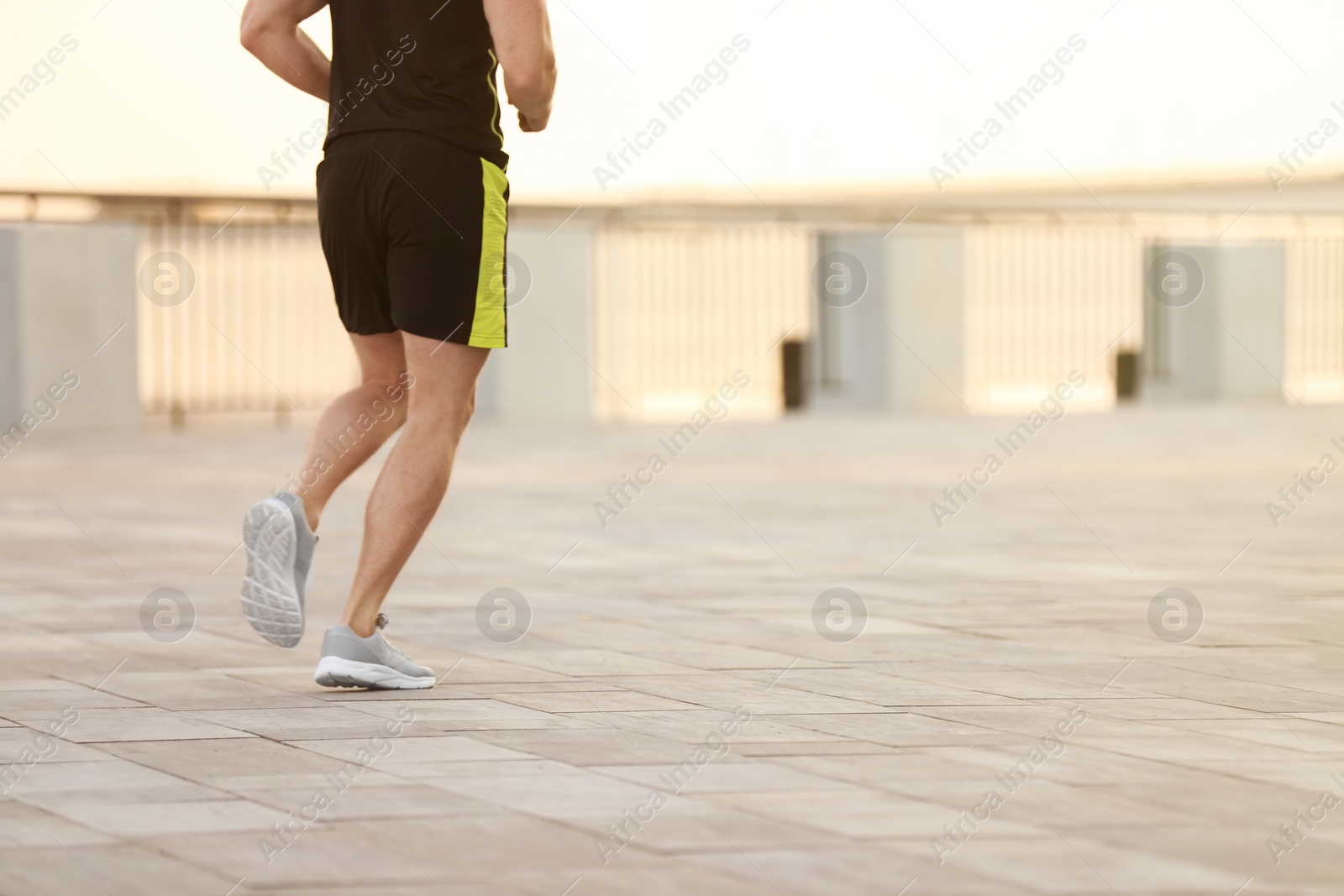 Photo of Young man running outdoors on sunny day