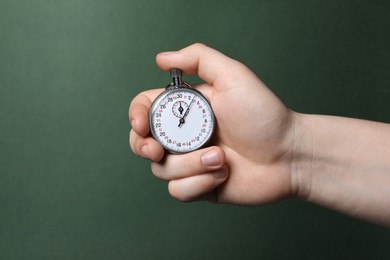 Man holding vintage timer on green background, closeup