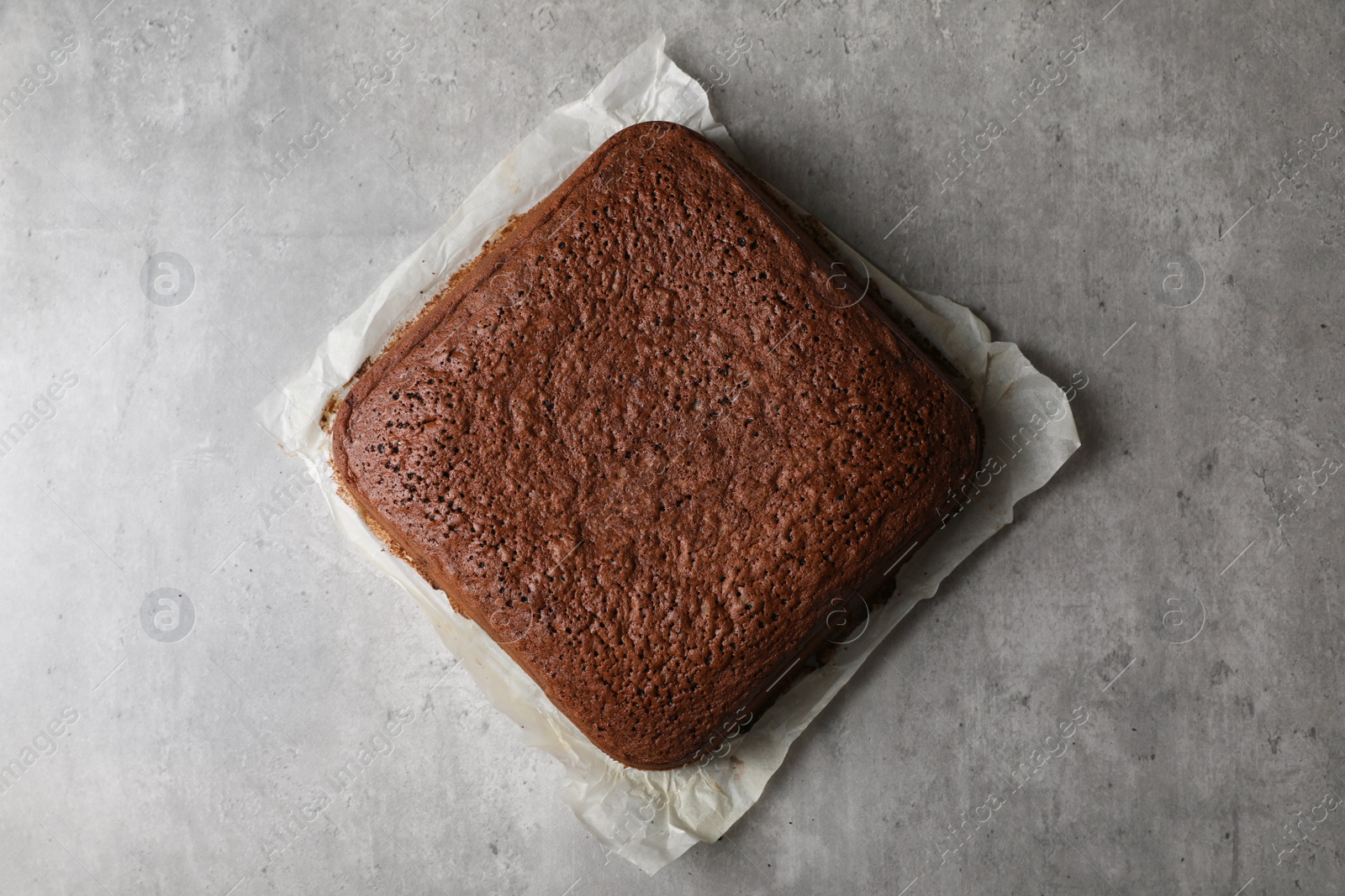 Photo of Homemade chocolate sponge cake on light grey table, top view