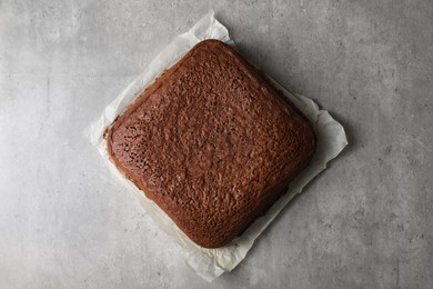 Homemade chocolate sponge cake on light grey table, top view