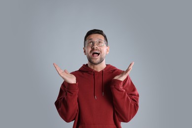 Portrait of emotional man in stylish glasses on light grey background