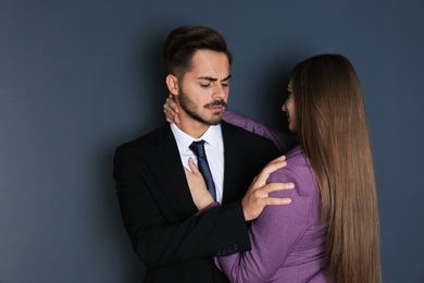 Photo of Woman molesting her male colleague on dark background. Sexual harassment at work