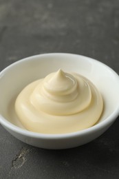 Photo of Fresh mayonnaise sauce in bowl on grey table, closeup