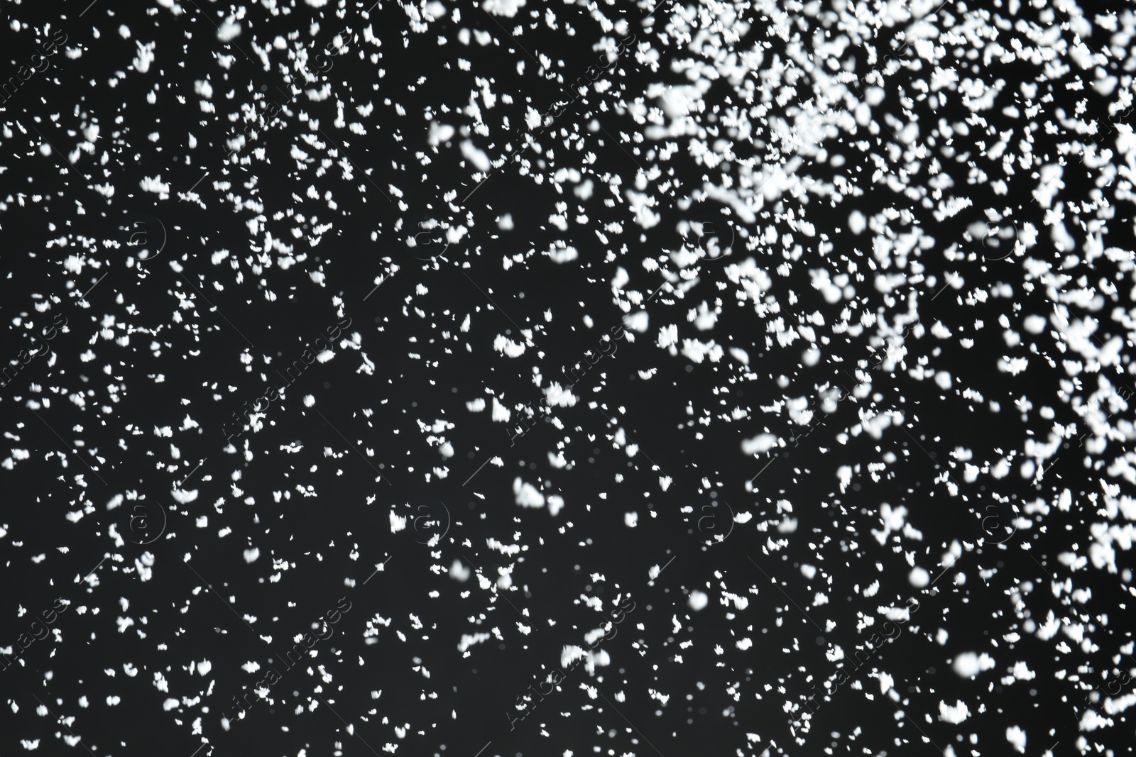 Photo of White snow falling down on black background