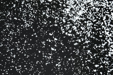 White snow falling down on black background