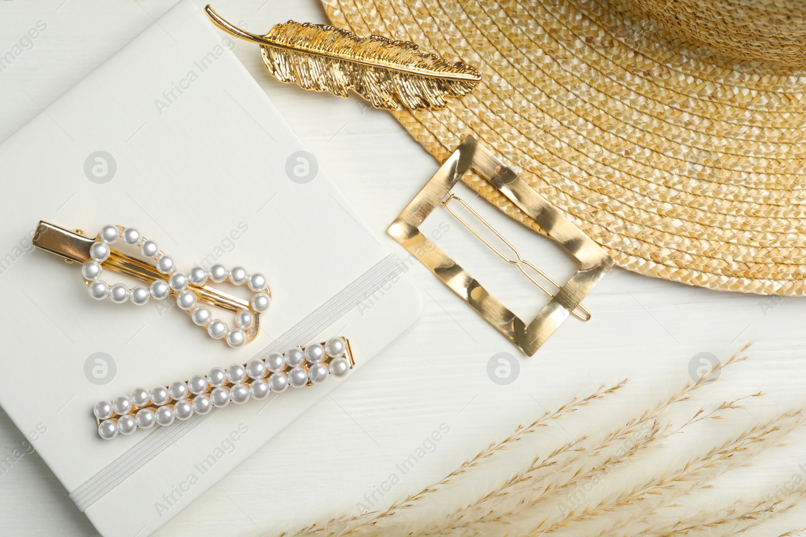 Photo of Stylish hair clips on white wooden table, flat lay