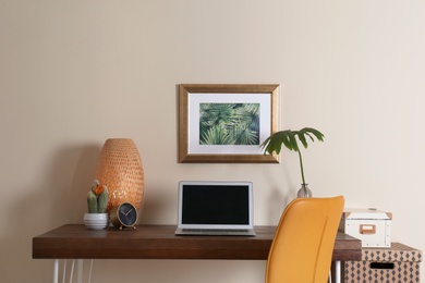 Photo of Stylish workplace with laptop on table in office