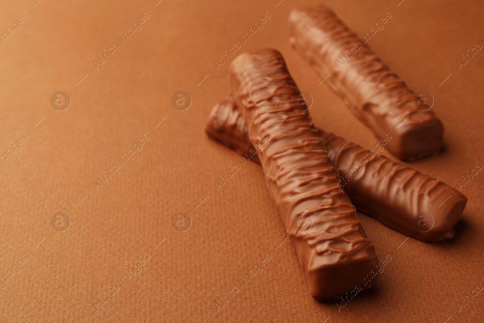 Photo of Sweet tasty chocolate bars on brown background. Space for text