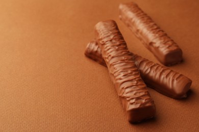 Sweet tasty chocolate bars on brown background. Space for text