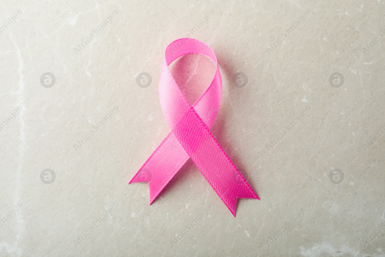 Photo of Pink ribbon on grey background, top view. Breast cancer awareness concept