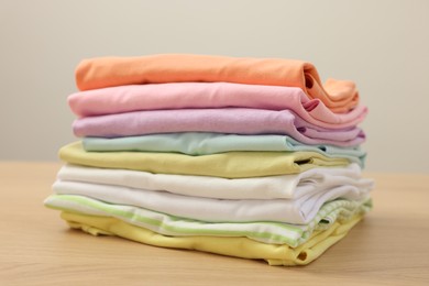 Photo of Stack of clean clothes on wooden table