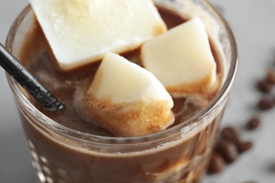 Coffee drink with milk ice cubes on grey background, closeup