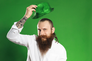 Photo of Bearded man with green hat on color background. St. Patrick's Day celebration