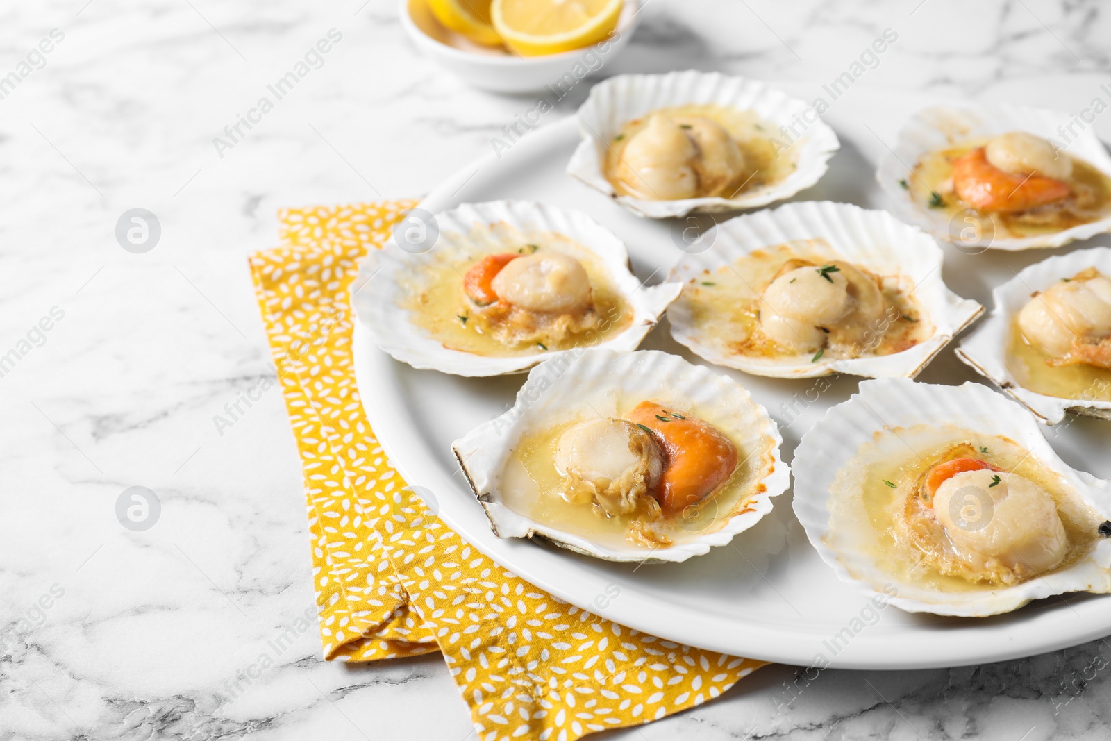 Photo of Fried scallops in shells on white marble table, closeup. Space for text