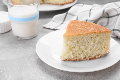 Photo of Piece of tasty sponge cake on grey table