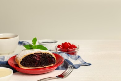 Delicious strudel with cherries and poppy seeds on white wooden table. Space for text