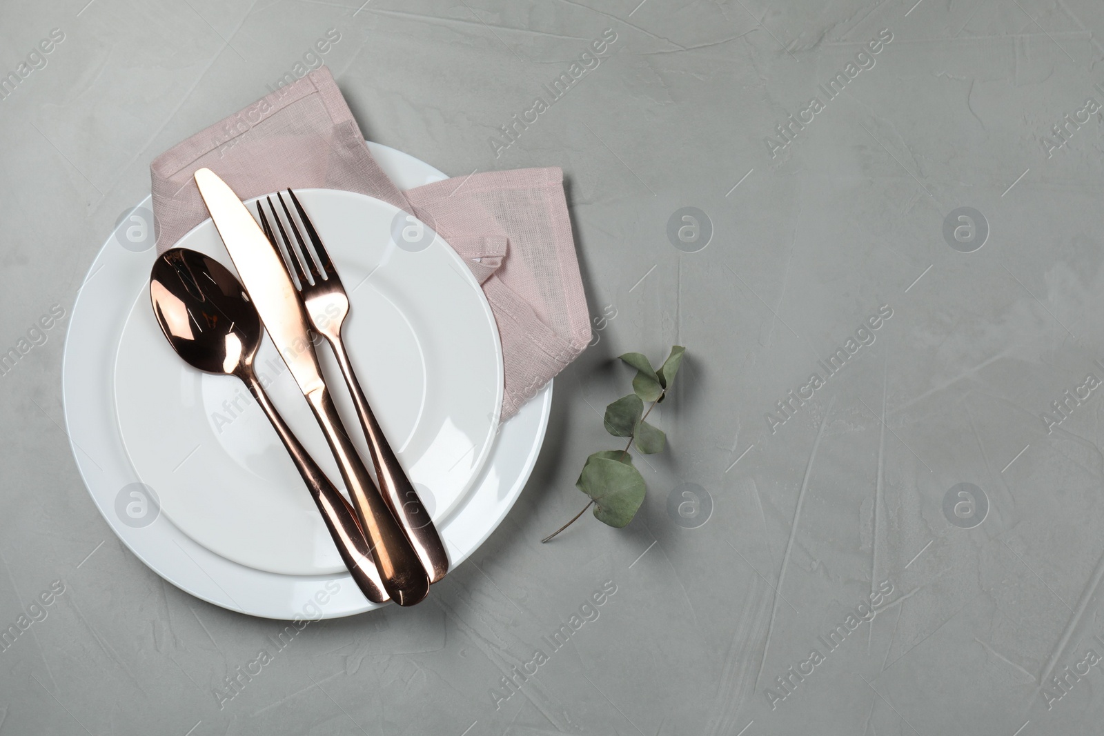 Photo of Stylish setting with elegant cutlery on grey table, top view. Space for text