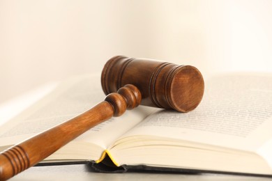 Photo of Law concept. Gavel and book on light table, closeup