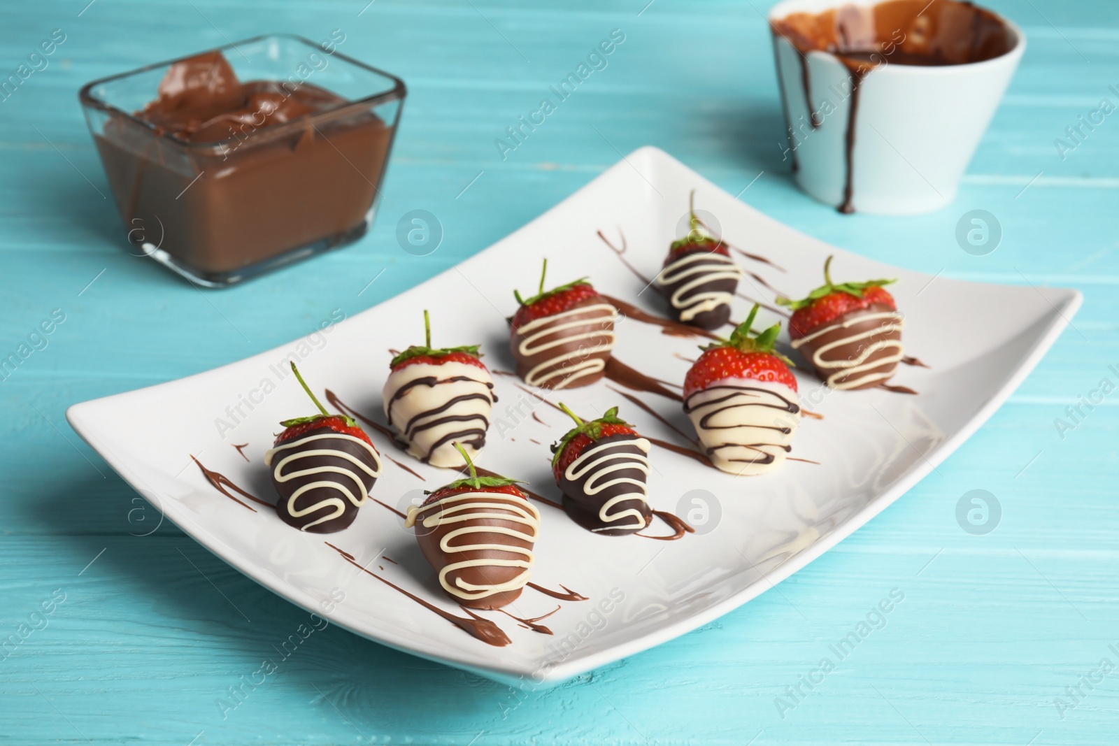 Photo of Plate with chocolate covered strawberries on table