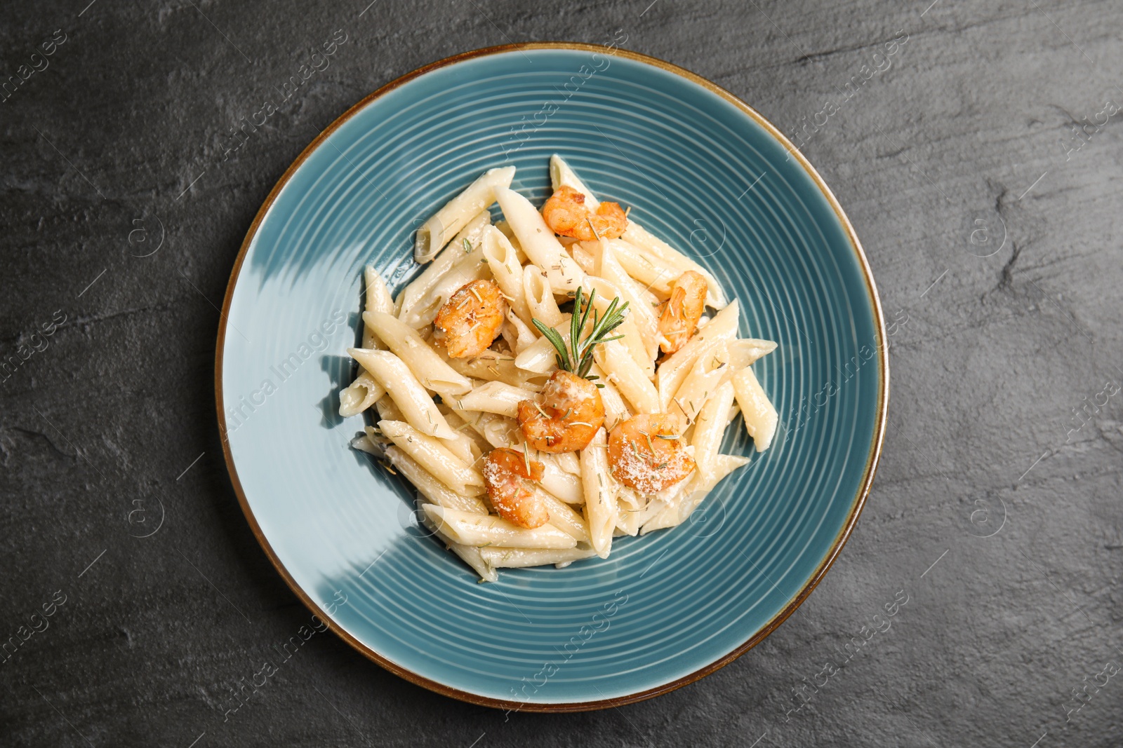 Photo of Delicious pasta with shrimps on black table, top view