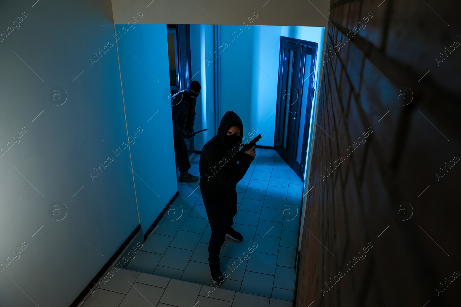 Photo of Dangerous criminals in masks with weapon in hallway