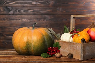 Photo of Happy Thanksgiving day. Composition with pumpkins, berries and pine cones on wooden table