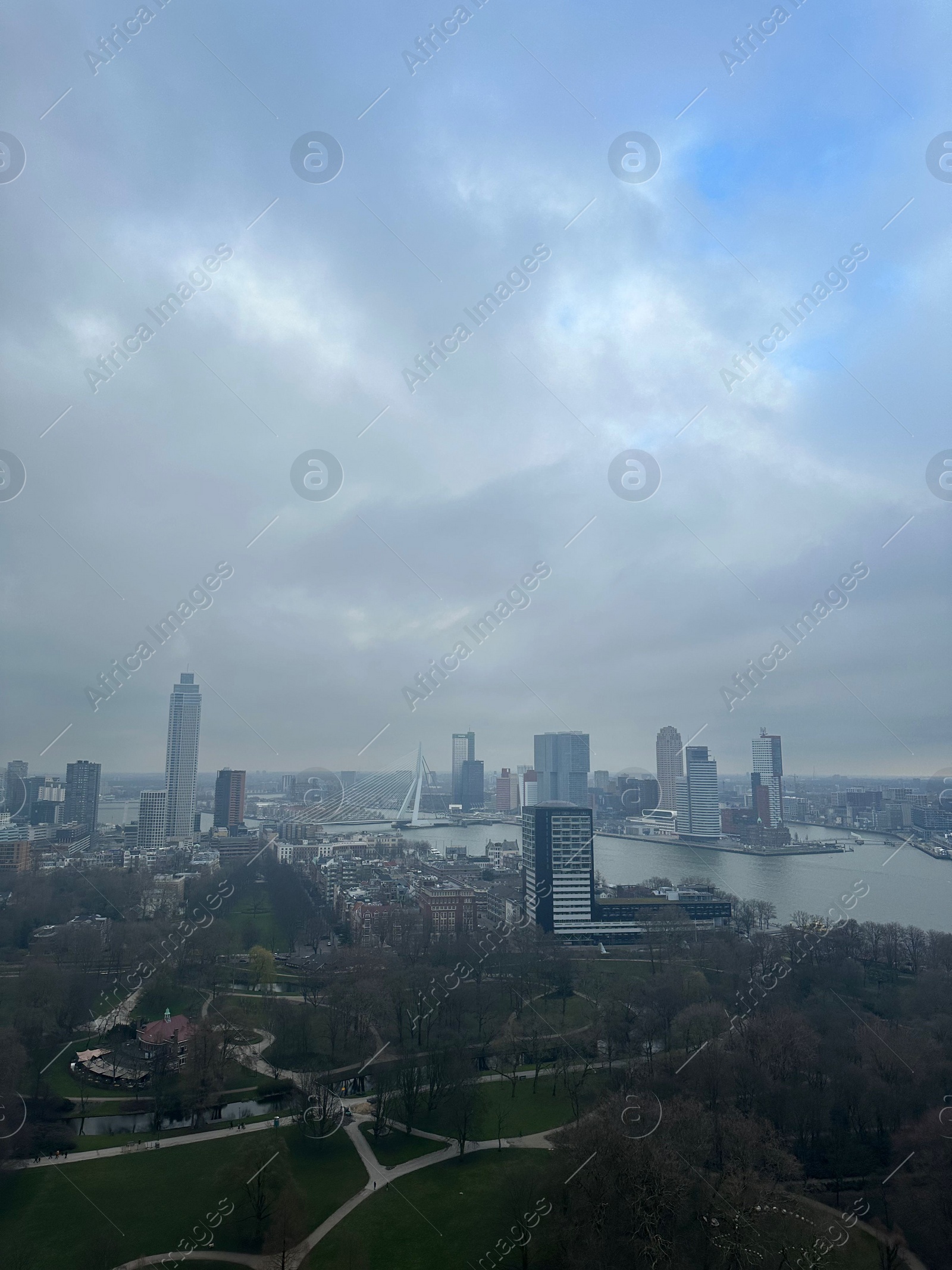 Photo of Picturesque view of city with modern buildings and park on cloudy day