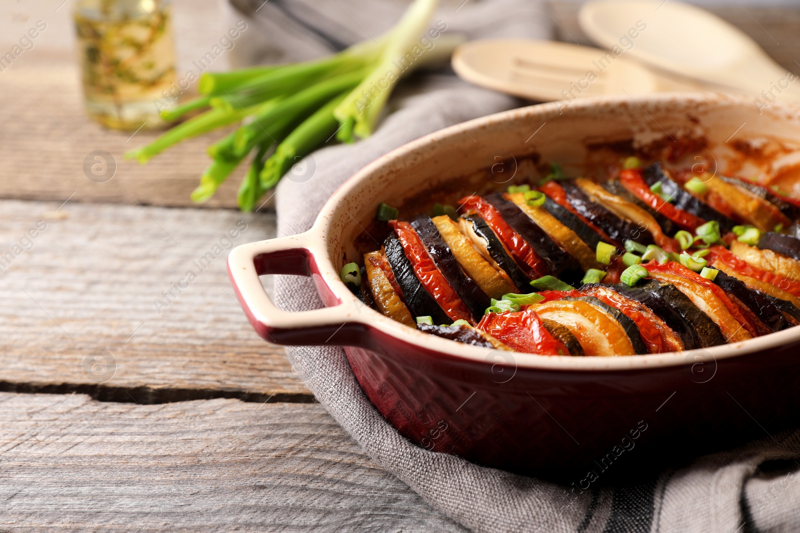 Photo of Delicious ratatouille in dish on wooden table, closeup