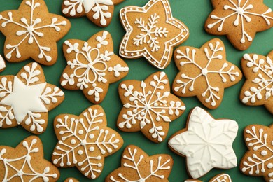 Photo of Tasty Christmas cookies with icing on green background, flat lay