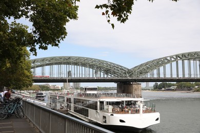Photo of Cologne, Germany - August 28, 2022: Picturesque view of a modern bridge over river and ferry boat