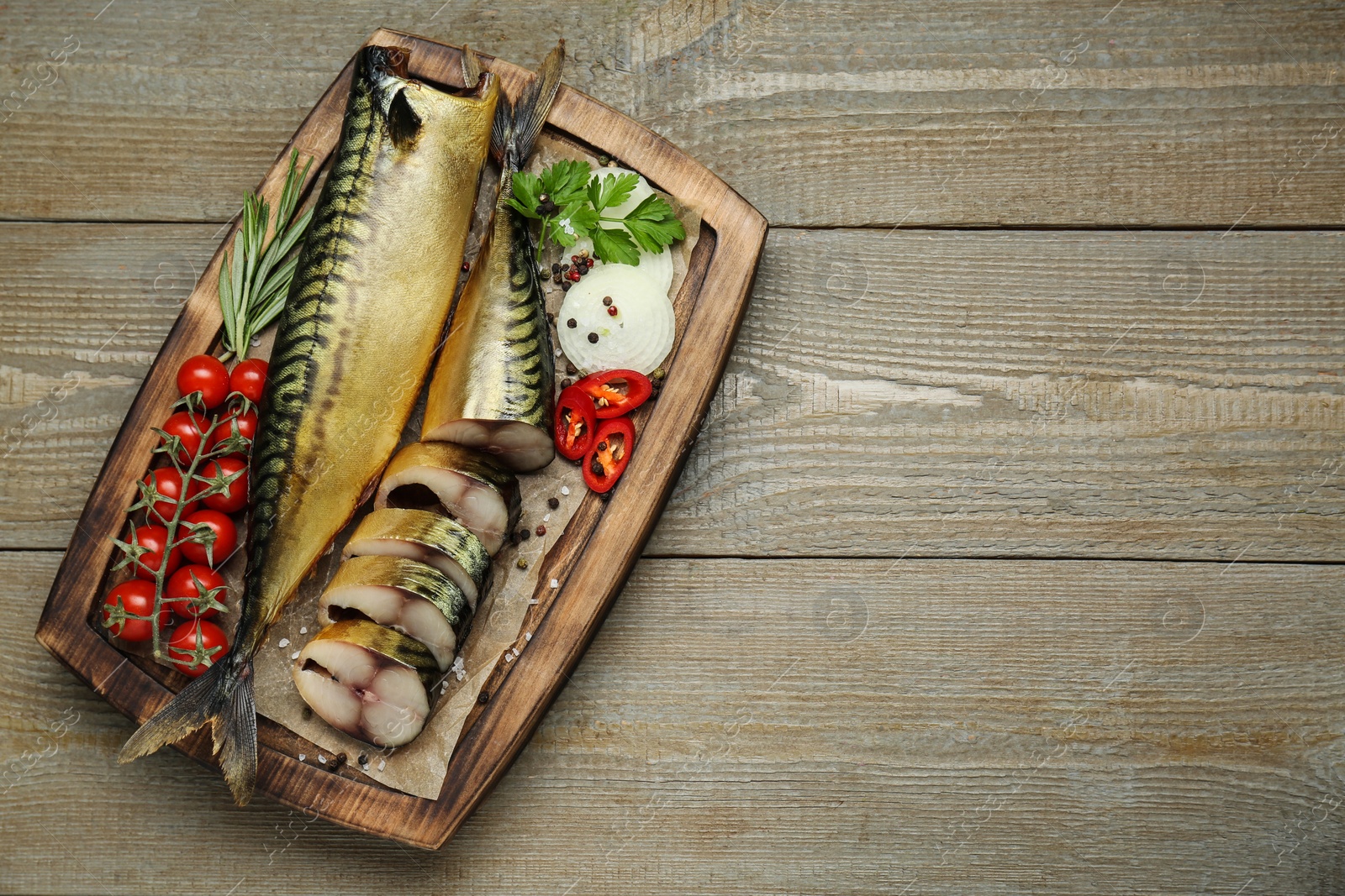 Photo of Delicious smoked mackerels and different products on wooden table, top view. Space for text