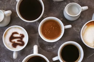 Photo of Cups of fresh aromatic coffee on grey background, top view