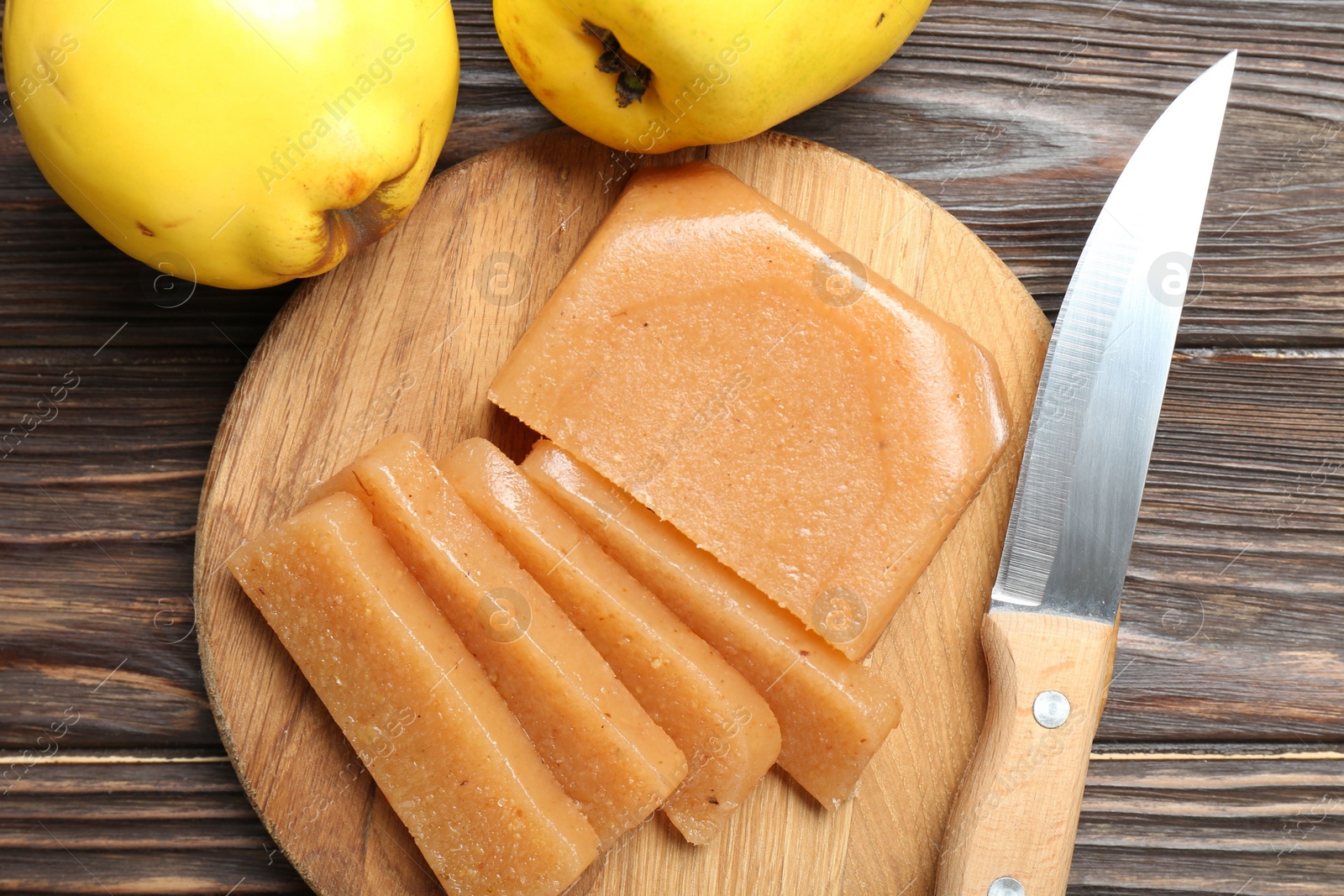 Photo of Tasty sweet quince paste, fresh fruits and knife on wooden table, flat lay