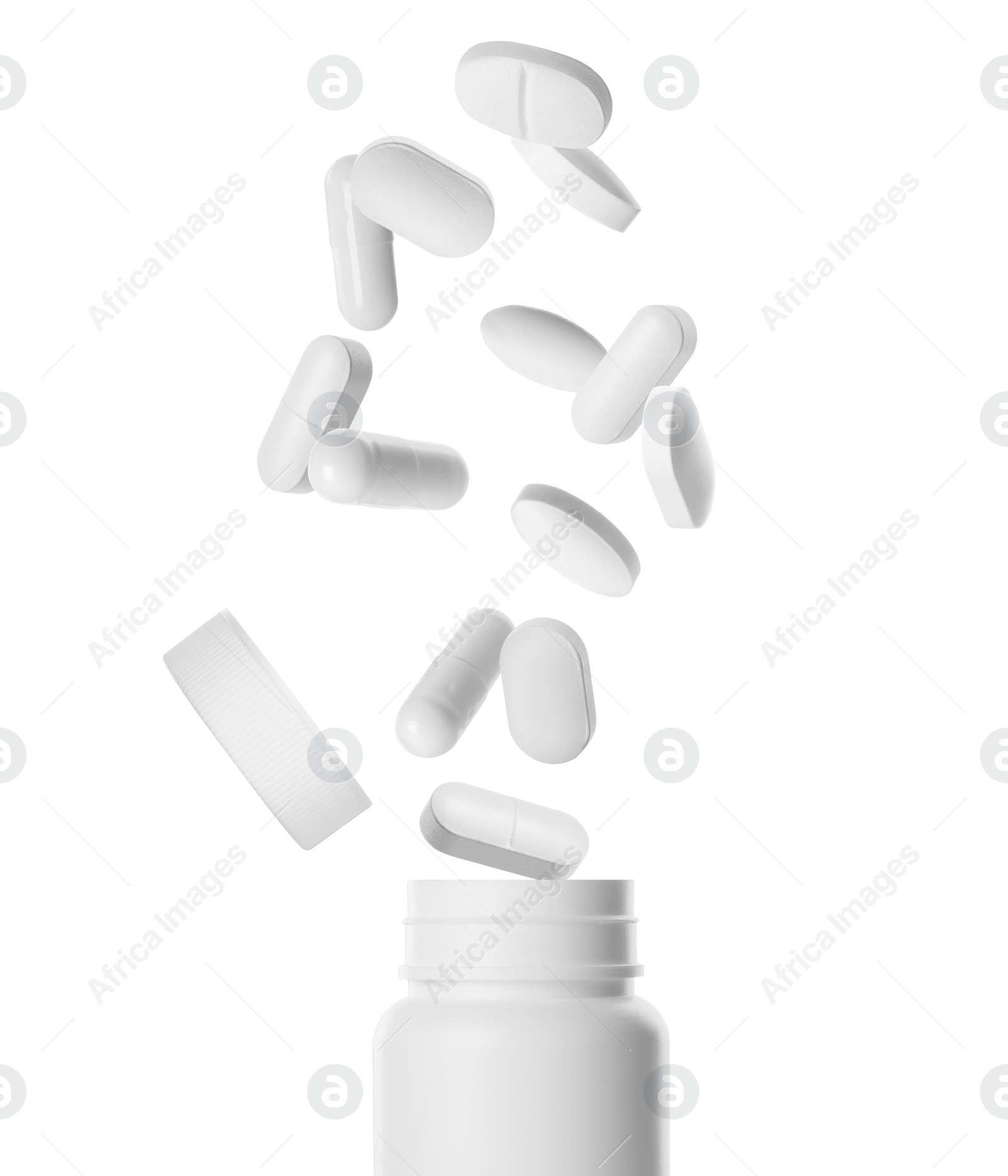 Image of Many different pills falling into bottle on white background