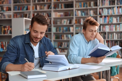 Photo of Young people studying at table in library