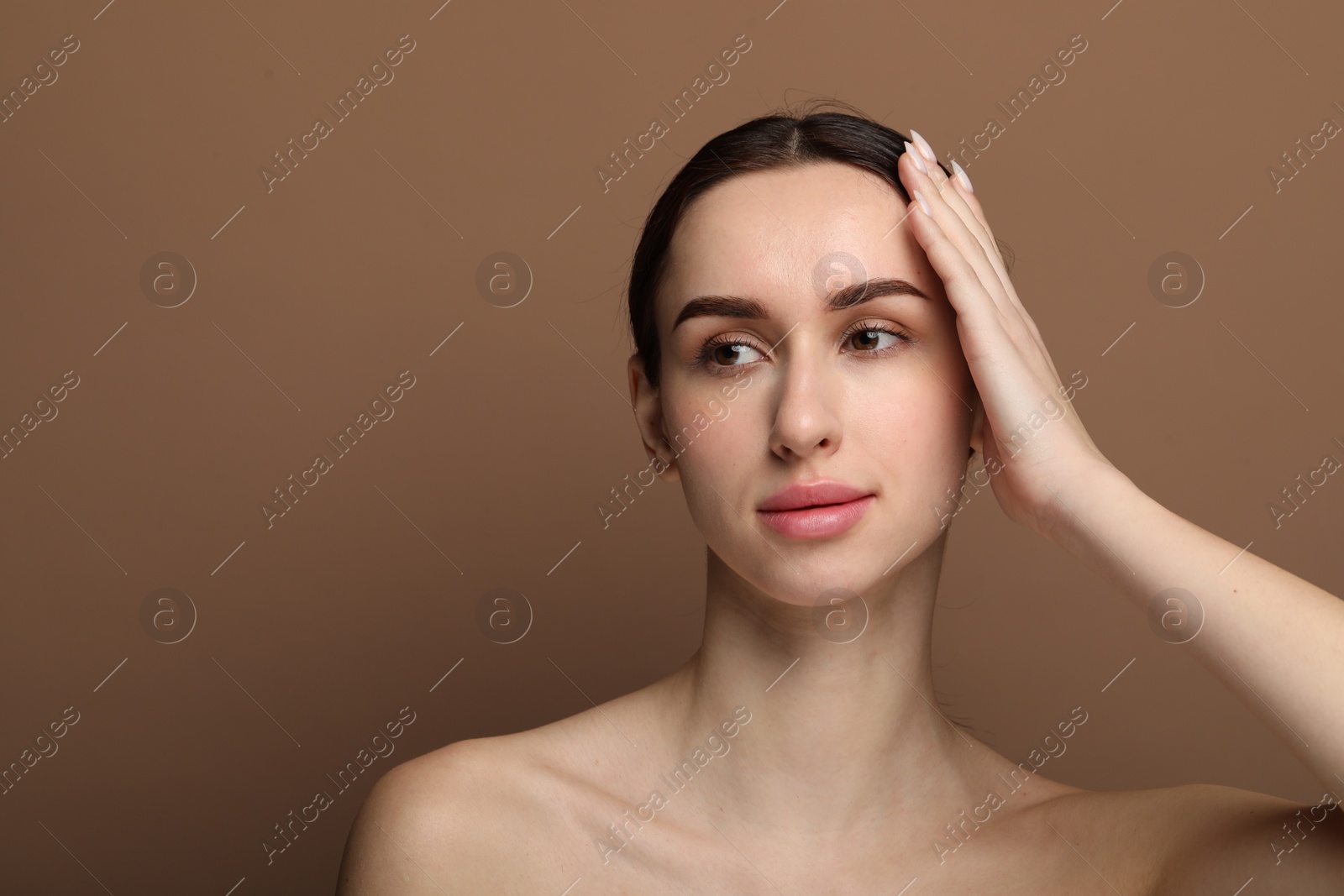 Photo of Portrait of beautiful young woman on brown background. Space for text