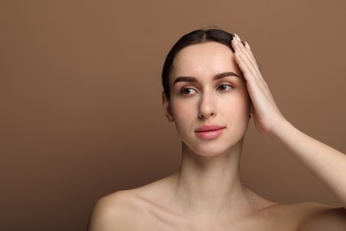 Portrait of beautiful young woman on brown background. Space for text