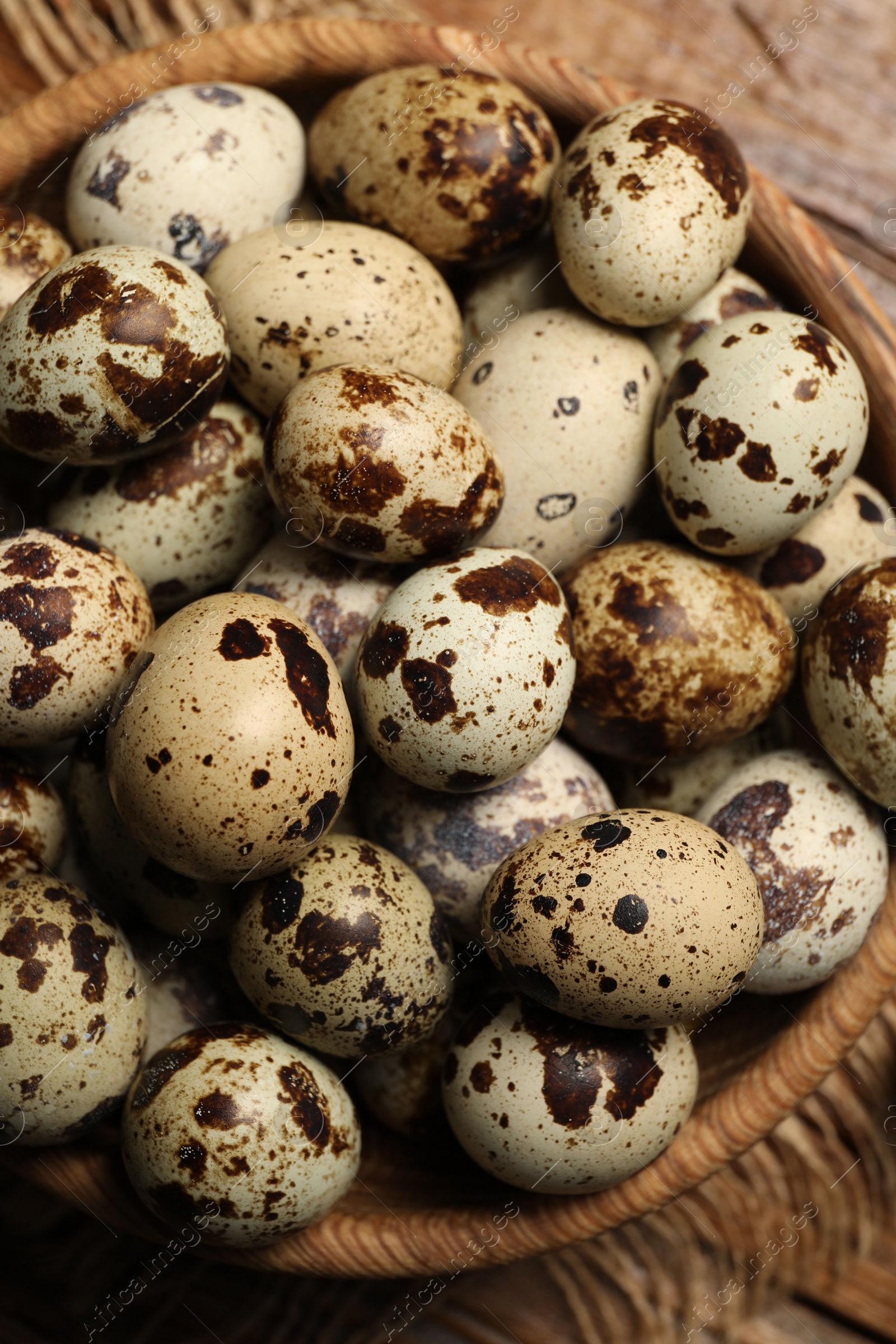 Photo of Wooden bowl with quail eggs on table, top view