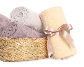 Photo of Wicker basket and rolled bath towels on white background