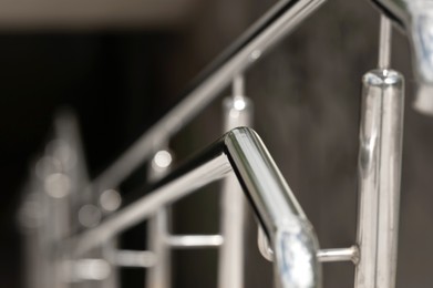 Photo of Shiny metal railing on blurred background, closeup. Space for text